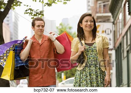 Stock Photo - Couple carrying shopping bags. Fotosearch