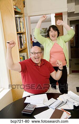 Couple celebrating after paying bills View Large Photo Image Stock Image - Couple celebrating after paying bills. Fotosearch