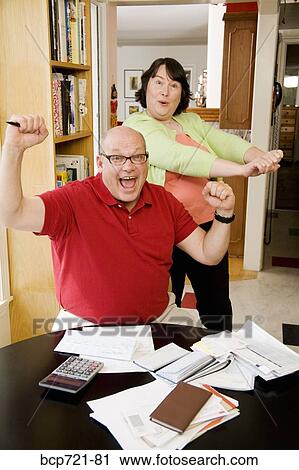 Couple celebrating after paying bills View Large Photo Image Stock Image - Couple celebrating after paying bills. Fotosearch
