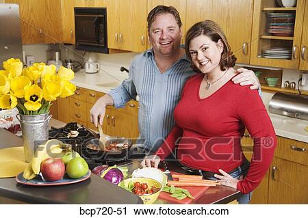 Stock Image - Couple cooking together. Fotosearch