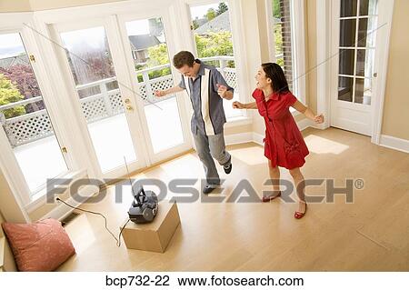Stock Image - Couple dancing in new house. Fotosearch