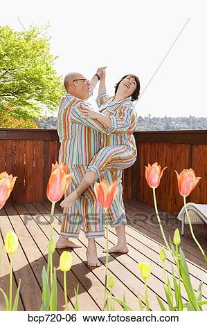 Couple dancing on the patio in matching pajamas View Large Photo Image Stock Photograph - Couple dancing on the patio in matching pajamas. Fotosearch