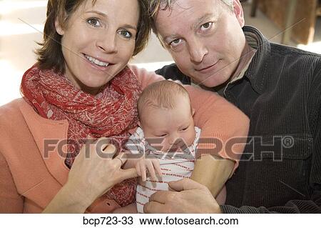 Couple holding newborn infant View Large Photo Image Stock Image - Couple holding newborn infant. Fotosearch