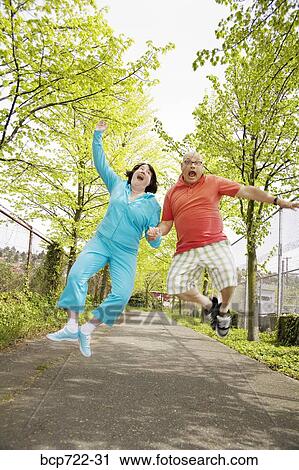 Couple jumping for joy outside View Large Photo Image Stock Image - Couple jumping for joy outside. Fotosearch