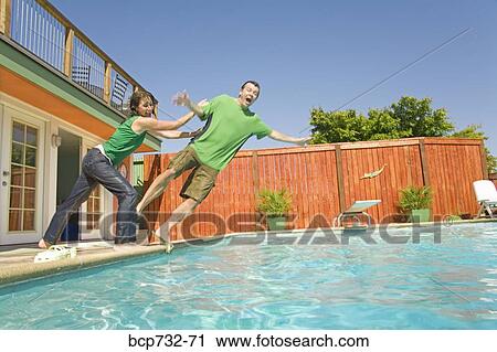 Couple jumping into swimming pool View Large Photo Image Stock Image - Couple jumping into swimming pool. Fotosearch