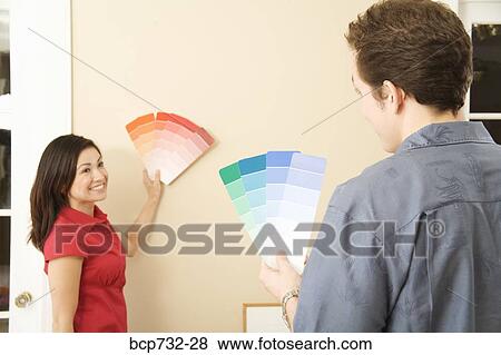 Stock Photo - Couple looking at paint swatches. Fotosearch