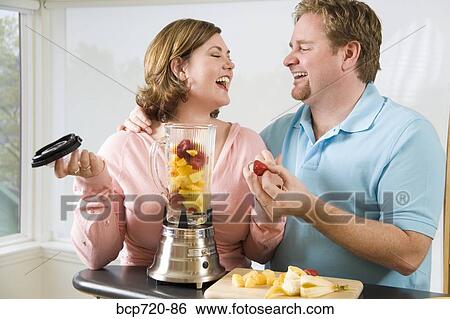 Couple making a smoothie View Large Photo Image Stock Photograph - Couple making a smoothie. Fotosearch