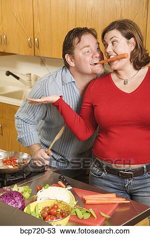 Couple playing with food while cooking View Large Photo Image Stock Image - Couple playing with food while cooking. Fotosearch