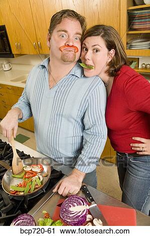 Couple playing with food while cooking View Large Photo Image Stock Image - Couple playing with food while cooking. Fotosearch