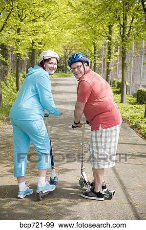 Couple riding scooters View Large Photo Image Stock Photo - Couple riding scooters. Fotosearch