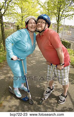 Couple riding scooters together View Large Photo Image Stock Image - Couple riding scooters together. Fotosearch