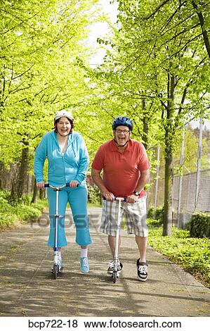 Couple riding scooters together View Large Photo Image Stock Photo - Couple riding scooters together. Fotosearch