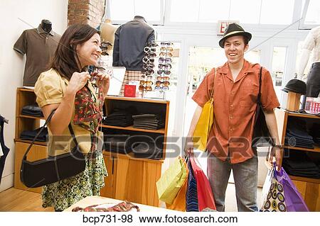 Stock Photo - Couple shopping in clothing store. Fotosearch