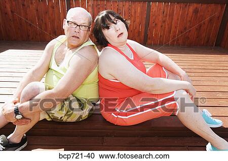 Stock Image - Couple sitting together on patio. Fotosearch
