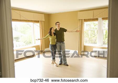 Couple standing in new house View Large Photo Image Stock Photograph - Couple standing in new house. Fotosearch