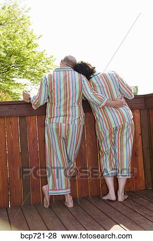 Couple standing on patio in matching pajamas View Large Photo Image Stock Photo - Couple standing on patio in matching pajamas. Fotosearch