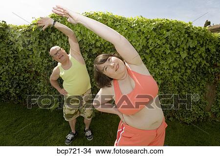 Couple stretching in backyard View Large Photo Image Picture - Couple stretching in backyard. Fotosearch