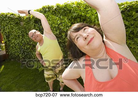 Couple stretching in backyard View Large Photo Image Stock Photo - Couple stretching in backyard. Fotosearch