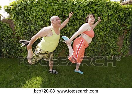 Stock Photo - Couple stretching in backyard. Fotosearch