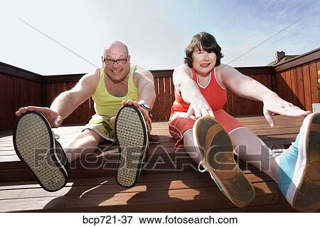 Couple stretching on patio View Large Photo Image Stock Photo - Couple stretching on patio. Fotosearch