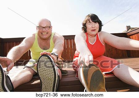 Couple stretching on patio View Large Photo Image Stock Photograph - Couple stretching on patio. Fotosearch