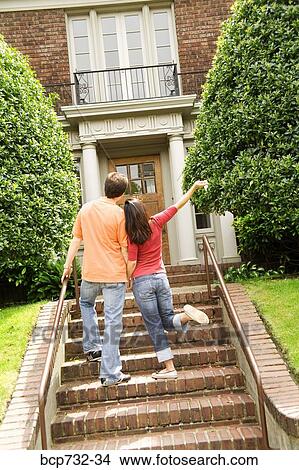 Couple walking towards house View Large Photo Image Picture - Couple walking towards house. Fotosearch