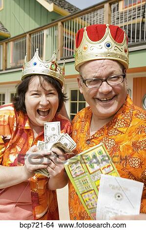 Picture - Couple wearing festive outfits and crowns. Fotosearch