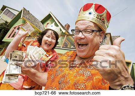 Stock Photograph - Couple wearing festive outfits and crowns. Fotosearch