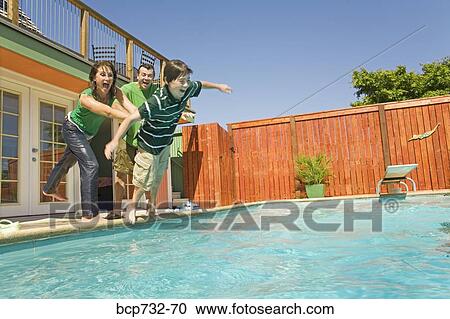 Family jumping into swimming pool View Large Photo Image Stock Image - Family jumping into swimming pool. Fotosearch