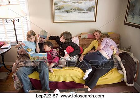 Family reading on sofa View Large Photo Image Stock Photo - Family reading on sofa. Fotosearch