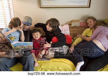 Family reading on sofa View Large Photo Image Stock Photo - Family reading on sofa. Fotosearch
