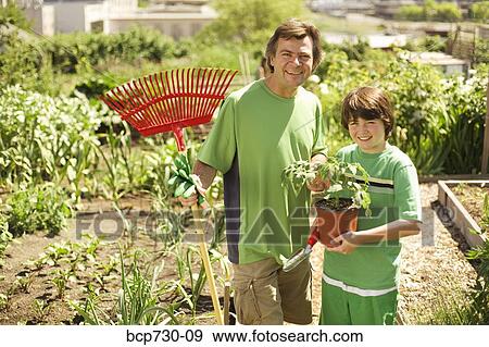 Father and son in vegetable garden View Large Photo Image Stock Photo - Father and son in vegetable garden. Fotosearch