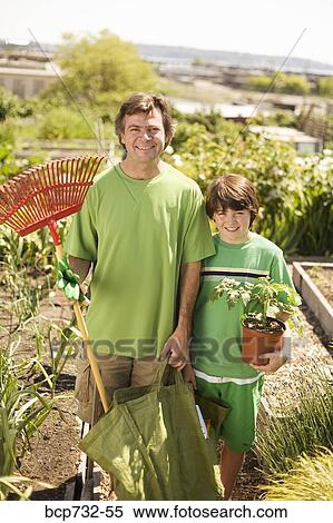 Stock Photography - Father and son in vegetable garden. Fotosearch