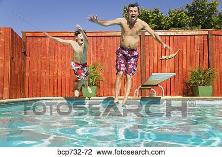 Father and son jumping into swimming pool View Large Photo Image Stock Image - Father and son jumping into swimming pool. Fotosearch