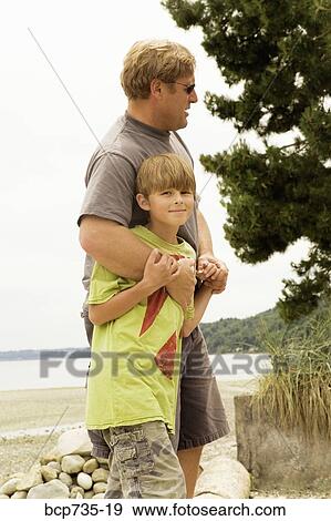 Father and son walking on beach View Large Photo Image Stock Photo - Father and son walking on beach. Fotosearch