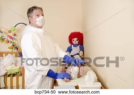 Stock Image - Father in decontamination suit changing baby’s diaper. Fotosearch