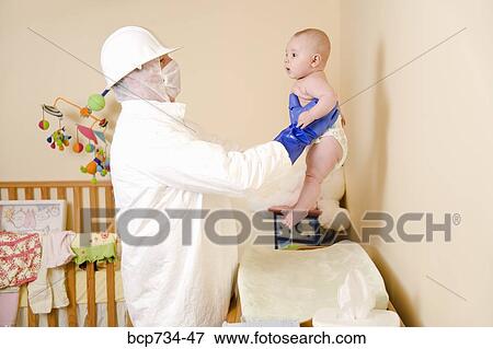 Father in decontamination suit holding baby View Large Photo Image Stock Photo - Father in decontamination suit holding baby. Fotosearch