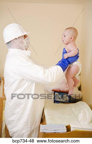 Father in decontamination suit holding baby View Large Photo Image Stock Photo - Father in decontamination suit holding baby. Fotosearch