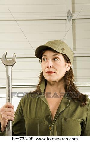 Female auto mechanic holding wrench View Large Photo Image Stock Photo - Female auto mechanic holding wrench. Fotosearch