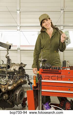 Female auto mechanic next to engine View Large Photo Image Picture - Female auto mechanic next to engine. Fotosearch