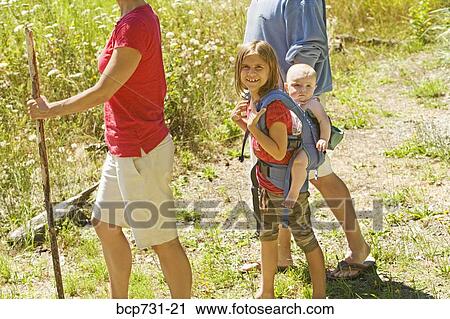 Girl carrying baby sibling on back View Large Photo Image Stock Image - Girl carrying baby sibling on back. Fotosearch