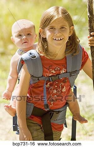 Girl carrying baby sibling on back View Large Photo Image Stock Photograph - Girl carrying baby sibling on back. Fotosearch