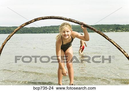 Girl in surf at beach View Large Photo Image Picture - Girl in surf at beach. Fotosearch