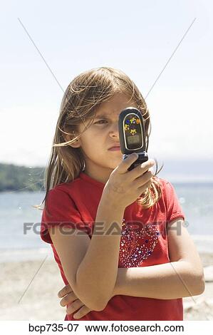 Girl looking at cell phone View Large Photo Image Stock Photo - Girl looking at cell phone. Fotosearch