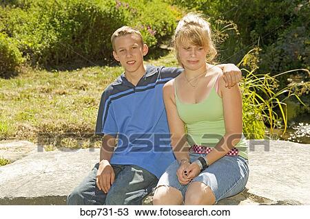 Girl making face at boy’s arm around her shoulder View Large Photo Image Stock Image - Girl making face at boy’s arm around her shoulder. Fotosearch