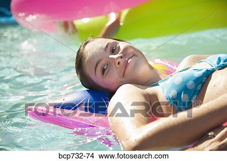 Picture - Girl on float in swimming pool. Fotosearch