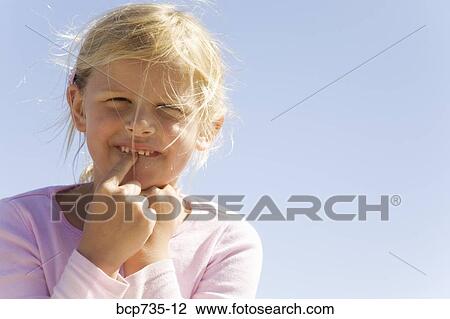 Stock Image - Girl pointing to new tooth. Fotosearch