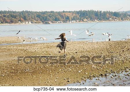 Girl running on beach in party dress View Large Photo Image Picture - Girl running on beach in party dress. Fotosearch