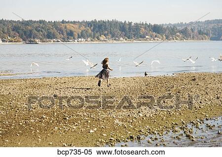Girl running on beach in party dress View Large Photo Image Stock Photography - Girl running on beach in party dress. Fotosearch