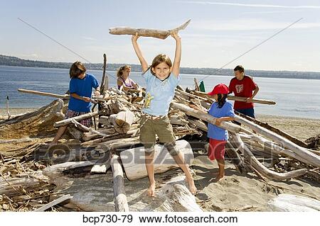 Stock Photo - Group of children building beach fort. Fotosearch